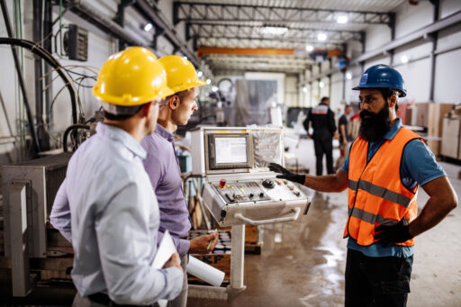 Engineers in factory hall, performing quality control