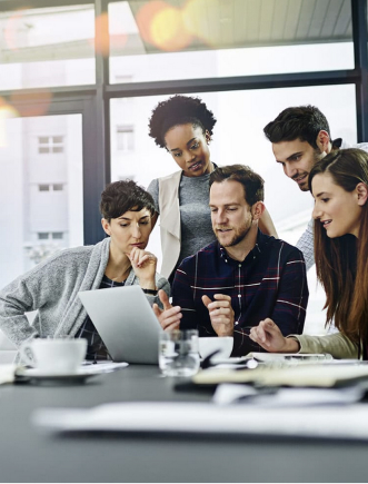 Group of professionals working around laptop in office